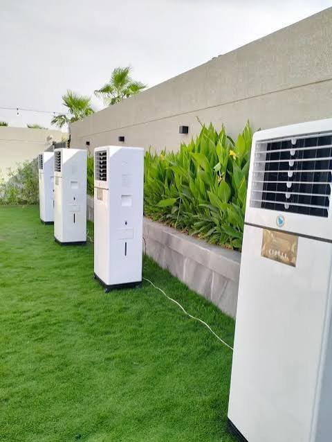 Portable air cooler with wheels and white finish in courtyard setting