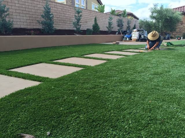 Beautiful backyard artificial grass installation showing perfect green appearance and comfortable outdoor space