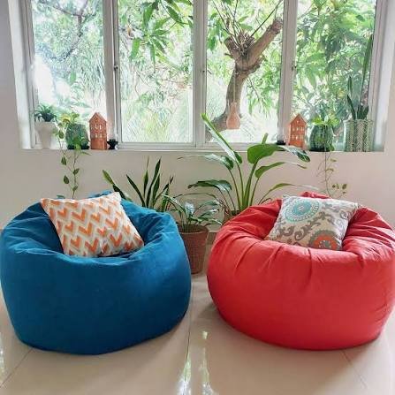 Modern orange and blue bean bag chairs in contemporary living room with elegant decor and pendant lighting