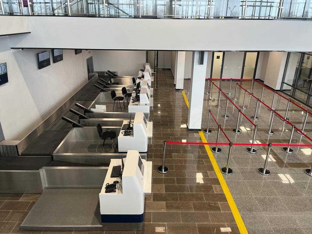 Branded check-in counter row with overhead LED signage and barriers rental Saudi Arabia