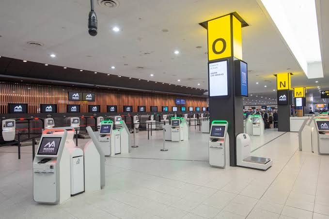Formal navy upholstered check-in counter row with numbered lane signage rental Saudi Arabia