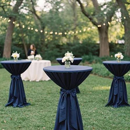 Outdoor garden event with elegant cocktail tables and navy linens