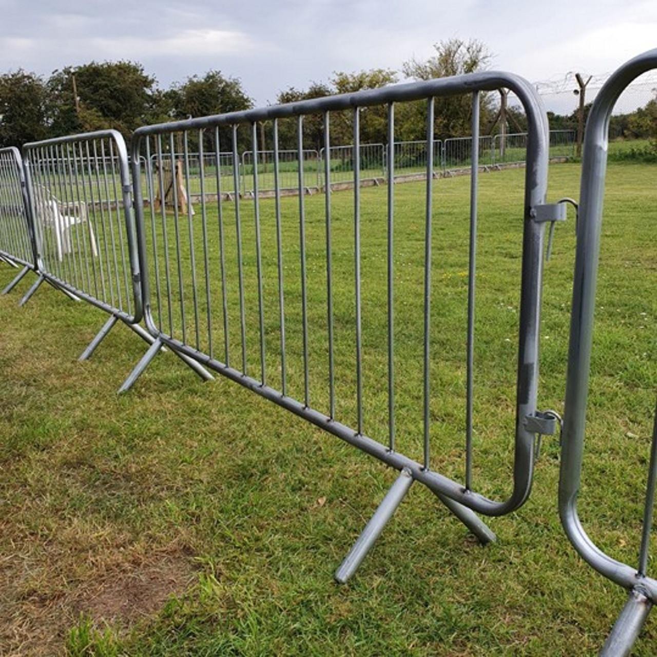 Multiple silver metal crowd control barriers lining street showing professional event perimeter control setup