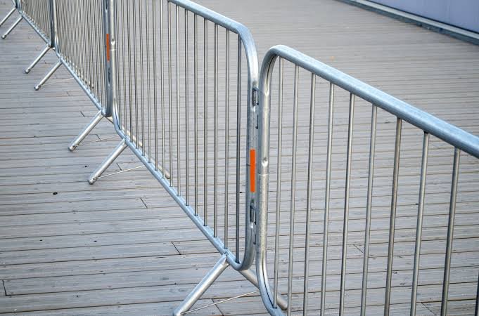 Yellow mobile crowd control barriers with wheels showing flexible portable barrier system for quick deployment