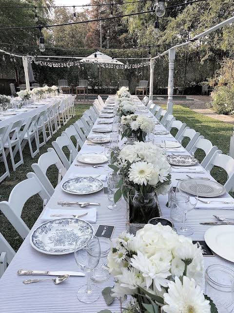 Mirrored banquet table with emerald velvet gold chairs and white floral runner engagement party Saudi Arabia
