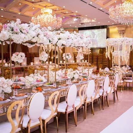 Grand ballroom engagement reception with gold chairs and floral arch backdrop rental Saudi Arabia
