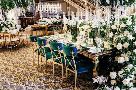 Intimate outdoor garden engagement dinner with white folding chairs and string lights Saudi Arabia