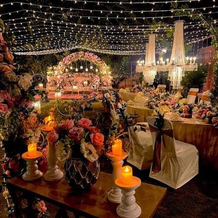 Ballroom wedding kosha stage with floral canopy and pink uplighting rental KSA