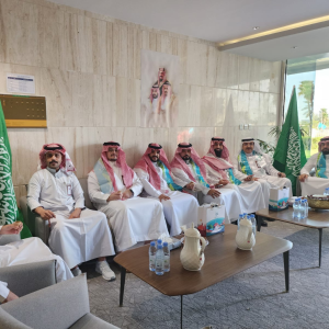 VIP armchair seating with wooden tables and green white floral arrangements in green themed ceremony hall National Day Saudi Arabia