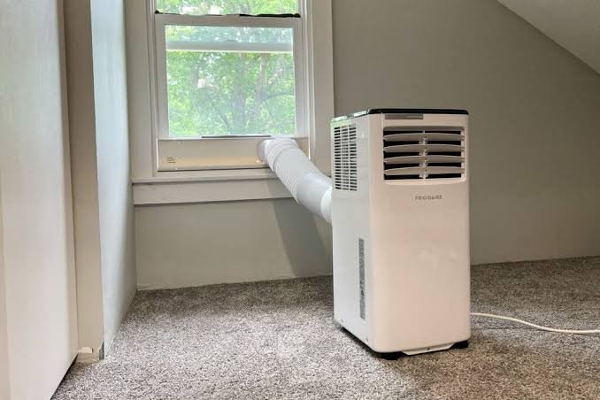 Multiple beige air conditioning units installed in large event venue with dramatic lighting