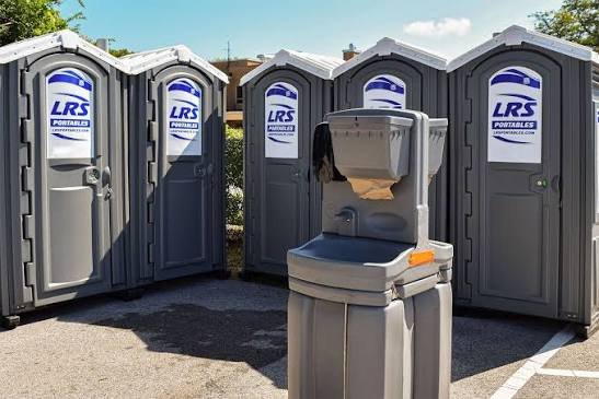 Premium green enclosed portable restroom with sink and shower facilities showing luxury amenities