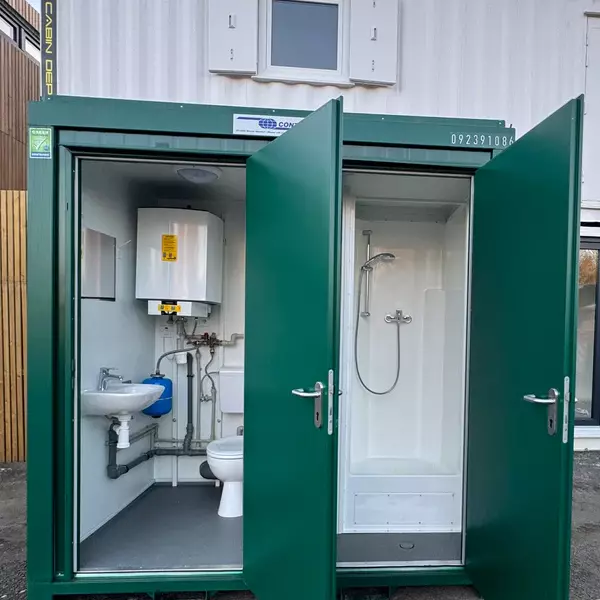 Multi-unit portable toilets with white and pink exterior featuring professional sanitation facilities