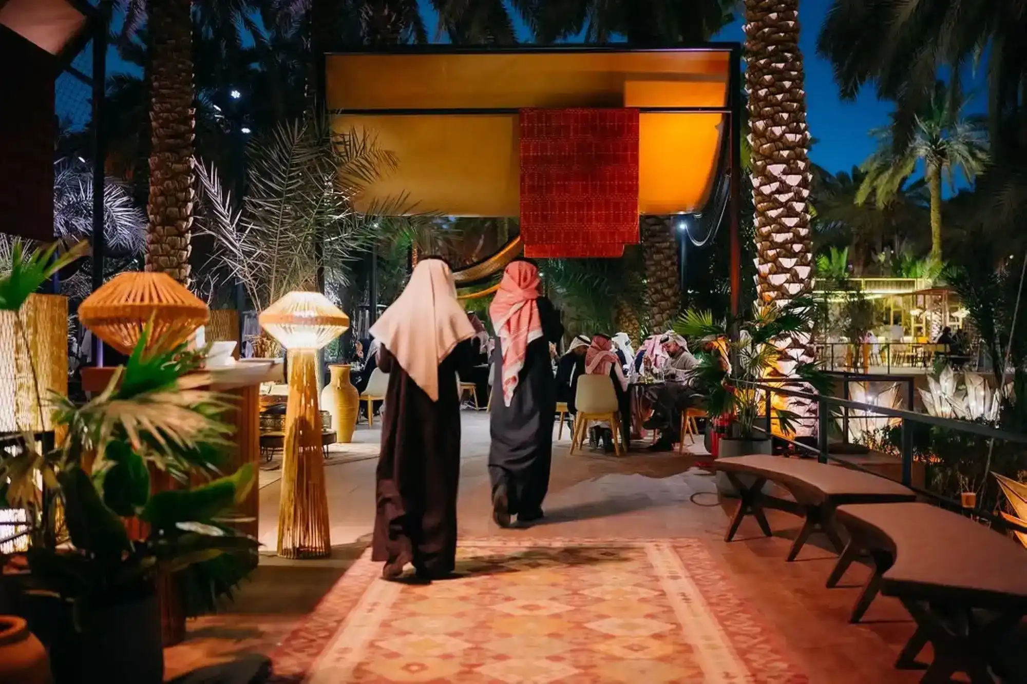 Community suhoor gathering with floor seating and shared plates Ramadan event Saudi Arabia