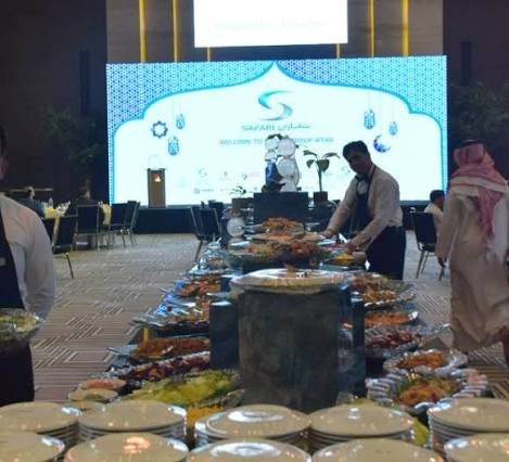 Guests walking through outdoor Ramadan iftar tent seating area at night event rental Saudi Arabia