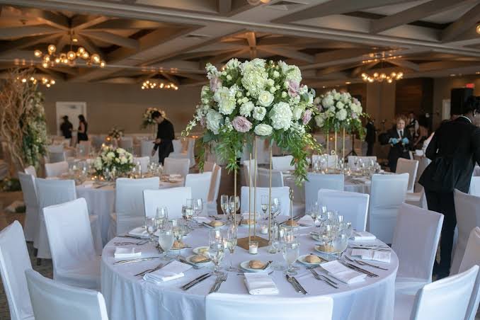 Formal ballroom wedding with round table, white linens, Chiavari chairs and gold accents